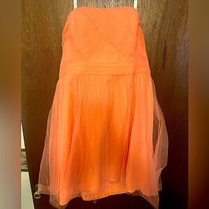 Salmon colored sleeveless David’s Bridal dress. Short dress with chest coverage.